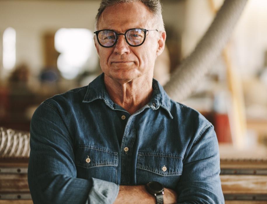 mature man in a workshop looking at the camera